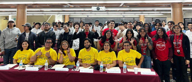 Sonriendo y posando para la foto, desde la parte inferior, jueces de la segunda edición del NASA International Space Apps Challenge Mexicali, comité organizador y participantes de todas las edades.
